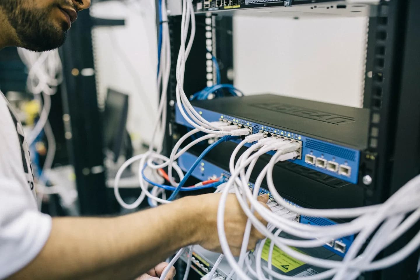 Engineer working on cables in a server rack